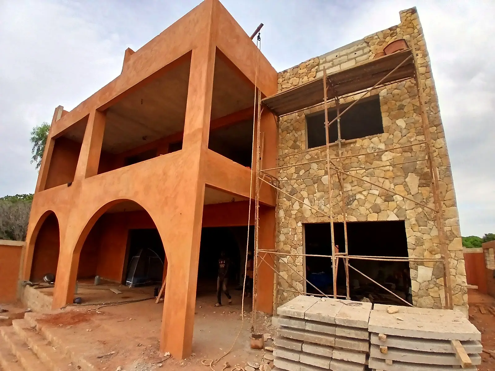 Villa à arcades et façade en pierre en chantier